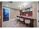 Well-lit bar area featuring seating and rich, dark-toned wooden cabinetry with a rustic-chic design at 980 E Tufts Ave, Cherry Hills Village, CO 80113