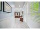 Bright bathroom features marble floors, marble half-walls, vanity with dark cabinets and large window with white blinds at 980 E Tufts Ave, Cherry Hills Village, CO 80113