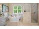 Bright bathroom with a standalone tub, large window, and a glass-enclosed shower at 980 E Tufts Ave, Cherry Hills Village, CO 80113