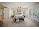 Spacious bedroom features a chandelier, bench, large windows, and access to the bathroom and outside at 980 E Tufts Ave, Cherry Hills Village, CO 80113