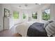 Sun-lit bedroom with white walls, neutral carpet, modern bed, and three windows overlooking green trees at 980 E Tufts Ave, Cherry Hills Village, CO 80113