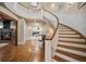 Elegant foyer showcasing a grand staircase, hardwood floors, and a glimpse of a cozy living area at 980 E Tufts Ave, Cherry Hills Village, CO 80113