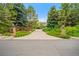 Welcoming front entrance with stone pillars, manicured landscaping, and a long private driveway at 980 E Tufts Ave, Cherry Hills Village, CO 80113