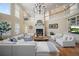 Spacious living room with high ceilings, fireplace, chandelier, and oversized sectional sofa at 980 E Tufts Ave, Cherry Hills Village, CO 80113