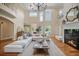 Bright living room boasts soaring ceilings, fireplace, and comfortable oversized sectional seating at 980 E Tufts Ave, Cherry Hills Village, CO 80113