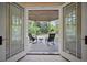 Inviting outdoor patio with rocking chairs seen through french doors at 980 E Tufts Ave, Cherry Hills Village, CO 80113