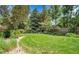 Expansive lawn in fenced yard offering plentiful green space and mature trees at 11496 E Wesley Ave, Aurora, CO 80014