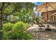 Lush backyard featuring a stone patio, garden beds, and mature trees at 11496 E Wesley Ave, Aurora, CO 80014