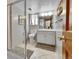 Well-lit bathroom with tiled floor, glass shower, white vanity, and modern fixtures at 11496 E Wesley Ave, Aurora, CO 80014
