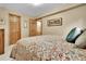 Comfortable bedroom with neutral walls and patterned bedspread, featuring natural wood doors and trim at 11496 E Wesley Ave, Aurora, CO 80014