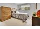 Bright bedroom with a classic dresser, window, and comfortable bed with patterned bedding at 11496 E Wesley Ave, Aurora, CO 80014