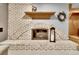 Close-up of a white brick fireplace with a decorative wreath on the mantle at 11496 E Wesley Ave, Aurora, CO 80014