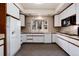 Bright kitchen with white cabinets, neutral countertops, and a bay window above the sink at 2552 E Alameda Ave # 47, Denver, CO 80209