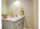 Well-lit bathroom featuring a white quartz countertop, modern sink, and a large frameless mirror at 3720 Jason St, Denver, CO 80211