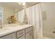 The stylish bathroom offers a double vanity, bathtub, and shower combination with a decorative shower curtain at 3720 Jason St, Denver, CO 80211
