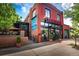 A charming corner building with a red brick facade and an inviting outdoor patio area at 3720 Jason St, Denver, CO 80211