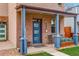 Charming front porch with blue columns, a blue door, brick exterior, and inviting seating area at 3720 Jason St, Denver, CO 80211