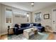 Bright living room with large windows, a plush blue sectional, and stylish decor creates a cozy atmosphere at 3720 Jason St, Denver, CO 80211