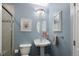 Bathroom featuring blue walls, a pedestal sink, decorative mirror and artwork, plus a tiled shower at 1996 Clipper Dr, Lafayette, CO 80026