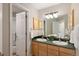 Well-lit bathroom with double sinks, modern fixtures, a large mirror, and a separate shower area at 1996 Clipper Dr, Lafayette, CO 80026