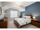 Comfortable bedroom with a blue accent wall, wood furniture, and soft natural light at 1996 Clipper Dr, Lafayette, CO 80026
