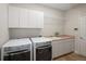 Functional laundry room with modern washer, dryer, cabinetry, and sink for convenience at 1996 Clipper Dr, Lafayette, CO 80026