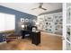 Modern office with a blue accent wall, built-in shelves, and a sleek black desk at 1996 Clipper Dr, Lafayette, CO 80026