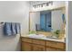 Bathroom featuring wood cabinets, granite countertop, and large mirror at 1738 N Franklin St # 2B, Denver, CO 80218