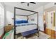 Stylish bedroom with canopy bed, wood floors, bench, and bright natural light at 1738 N Franklin St # 2B, Denver, CO 80218