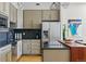 Bright kitchen featuring stainless steel appliances, bar seating, and hardwood floors at 1738 N Franklin St # 2B, Denver, CO 80218