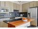 Modern kitchen with stainless steel appliances, black countertops, and wood breakfast bar at 1738 N Franklin St # 2B, Denver, CO 80218