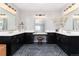Bright bathroom with dual vanities, black cabinetry, and stylish herringbone tile flooring at 10580 Greycliffe Dr, Highlands Ranch, CO 80126