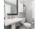 A half-bathroom showcases a stylish vanity, toilet with decorative tile floor and a charming cabinet with sliding barn door at 10580 Greycliffe Dr, Highlands Ranch, CO 80126