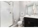 Bright bathroom featuring a glass enclosed shower, toilet, vanity with storage, and neutral wall paint at 10580 Greycliffe Dr, Highlands Ranch, CO 80126