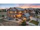 Beautiful dusk view of a two-story home with manicured lawn, welcoming porch and a private driveway with basketball hoop at 10580 Greycliffe Dr, Highlands Ranch, CO 80126