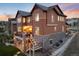 Exterior shot of the rear of a two-story home with patio, staircase and well-maintained yard at 10580 Greycliffe Dr, Highlands Ranch, CO 80126