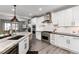 Well-lit kitchen featuring an island, stainless steel appliances, and white cabinets with a view to a comfortable living room at 10580 Greycliffe Dr, Highlands Ranch, CO 80126