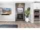 Living room with stone fireplace, large screen TV, and built-in ovens at 10580 Greycliffe Dr, Highlands Ranch, CO 80126
