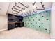 Finished basement boasts a climbing wall, custom shelving and unique industrial lighting at 21743 Farmingdale Ct, Parker, CO 80138