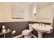 Charming half-bathroom with wainscoting, modern fixtures, decorative mirror, and elegant decor at 8657 Aberdeen Cir, Highlands Ranch, CO 80130