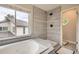 A modern bathroom featuring tile work, natural light, and a luxurious soaking tub at 8657 Aberdeen Cir, Highlands Ranch, CO 80130