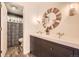 Stylish bathroom featuring double sinks, a round mirror, and a shower with patterned curtain at 8657 Aberdeen Cir, Highlands Ranch, CO 80130