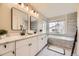 Bright bathroom with dual vanity sinks, a soaking tub, and modern fixtures create a spa-like experience at 8657 Aberdeen Cir, Highlands Ranch, CO 80130