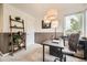Well-lit home office with a ladder bookshelf and a comfortable chair is perfect for remote work and study at 8657 Aberdeen Cir, Highlands Ranch, CO 80130