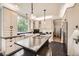 Bright kitchen features shaker cabinets, dark countertops, a large island, and stainless steel appliances at 8657 Aberdeen Cir, Highlands Ranch, CO 80130