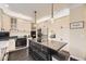 Spacious kitchen with island, stainless appliances, white cabinets, and stylish pendant lighting at 8657 Aberdeen Cir, Highlands Ranch, CO 80130
