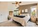 Spacious main bedroom with a fan, a plush bed, and abundant natural light from the large windows at 8657 Aberdeen Cir, Highlands Ranch, CO 80130