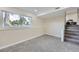 This carpeted basement room offers a large window with street views and a staircase leading up at 1880 E 81St Pl, Denver, CO 80229