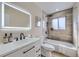 Modern bathroom features a sleek vanity, backlit mirror, and a tiled tub with shower combo at 1880 E 81St Pl, Denver, CO 80229