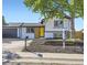 Exterior view of a modern home with a yellow door, black garage and well-maintained yard at 1880 E 81St Pl, Denver, CO 80229